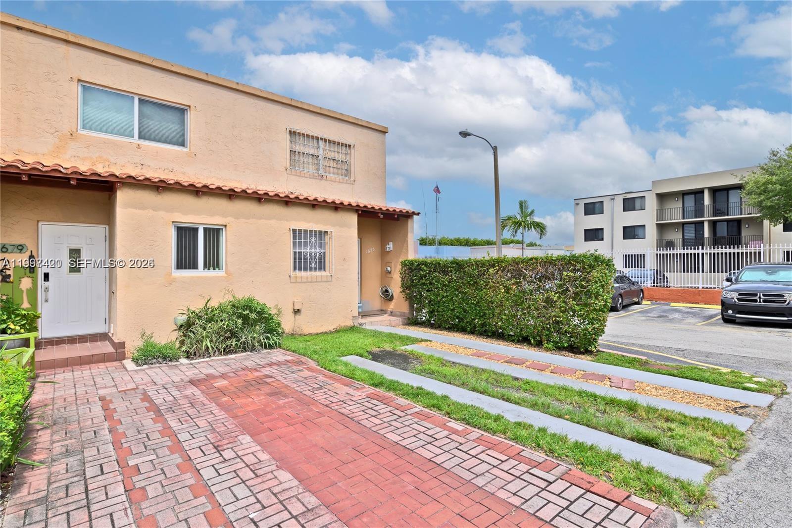 1675 West 57th Street, Unit 514 Hialeah, FL 33012 - Photo 22 of 26 a front view of a house with garden