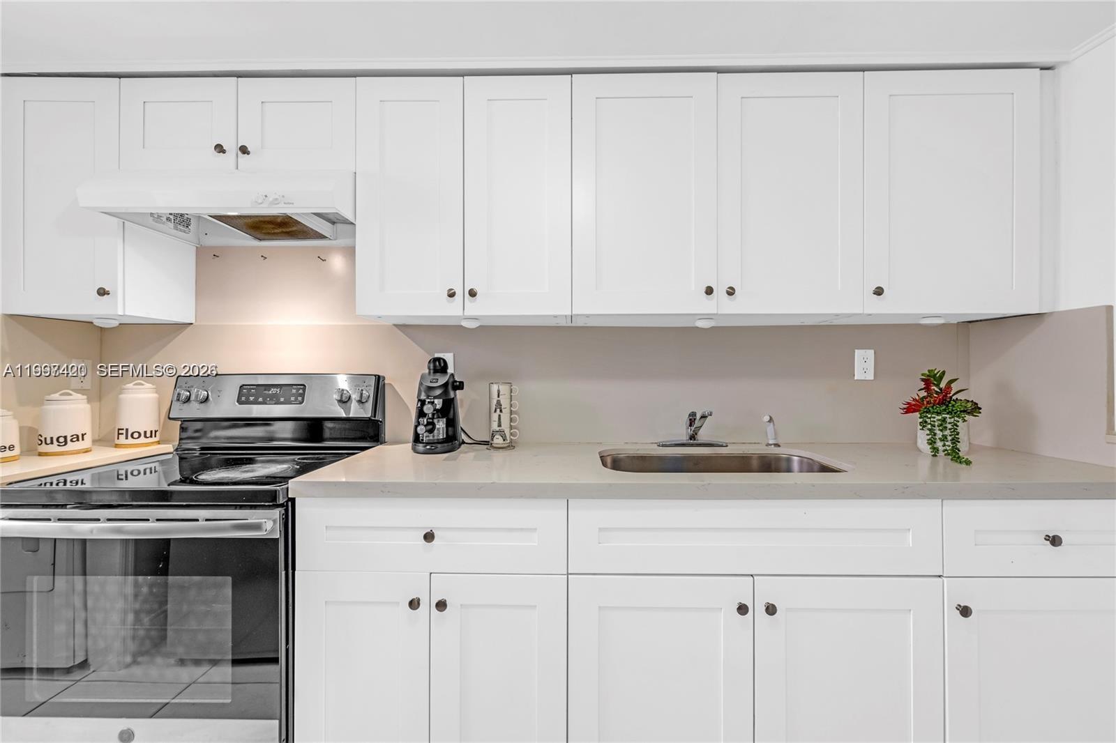 1675 West 57th Street, Unit 514 Hialeah, FL 33012 - Photo 3 of 26 a kitchen with stainless steel appliances granite countertop a sink and a stove