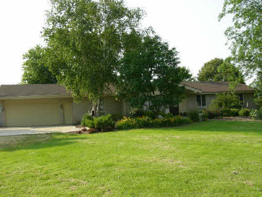 6338 Centerville Road Poplar Grove, IL 61065 - Photo 1 of 6 a front view of a house with a yard and trees