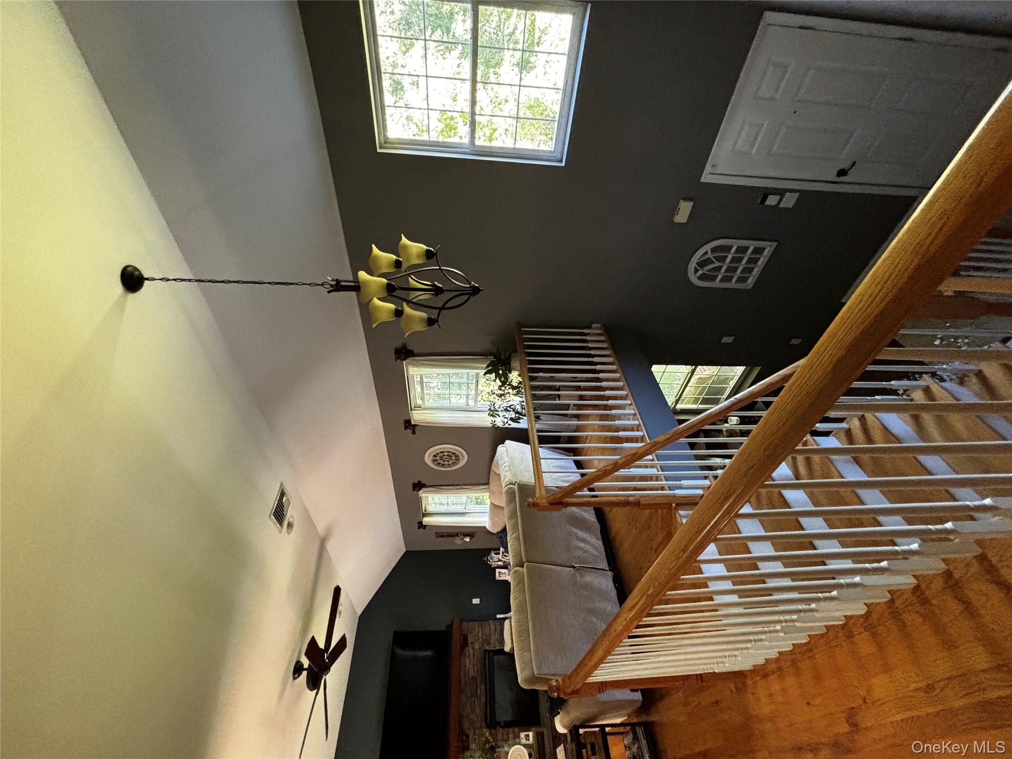 62 Triangle Of Clearwater Road Highland, NY 12528 - Photo 14 of 46 Stairway with lofted ceiling, wood finished floors, a chandelier, and ceiling fan