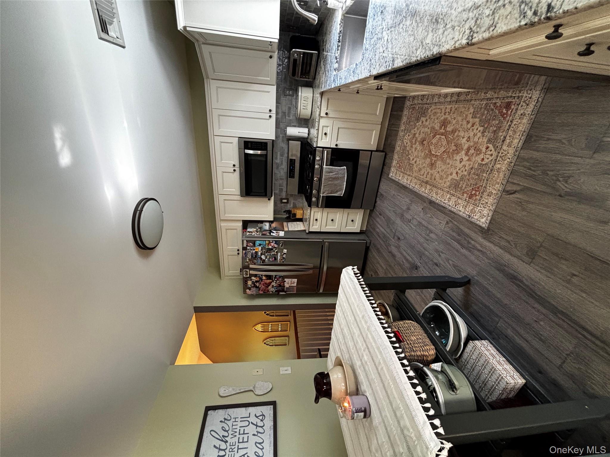 62 Triangle Of Clearwater Road Highland, NY 12528 - Photo 21 of 46 Kitchen with stainless steel appliances, light stone countertops, tasteful backsplash, dark wood-style floors, and white cabinetry