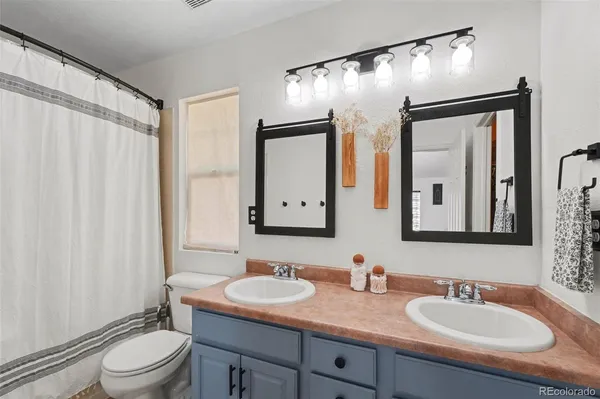 a bathroom with a granite countertop sink toilet a mirror and shower