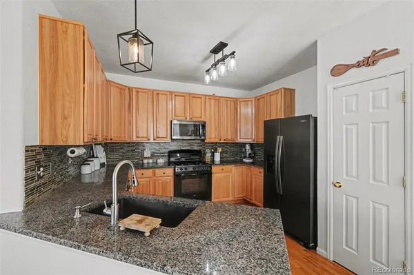 a kitchen with stainless steel appliances granite countertop a refrigerator and a stove top oven
