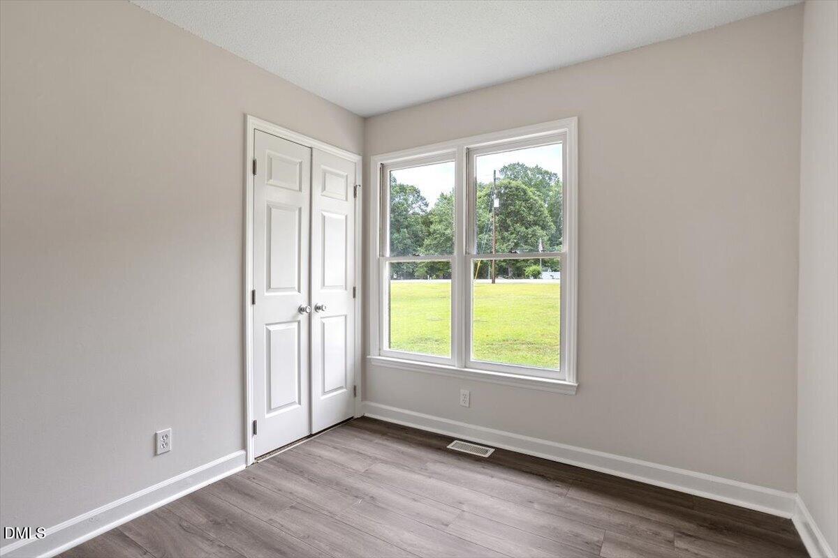 805 Rand Road Garner, NC 27529 - Photo 35 of 38 an empty room with wooden floor and windows