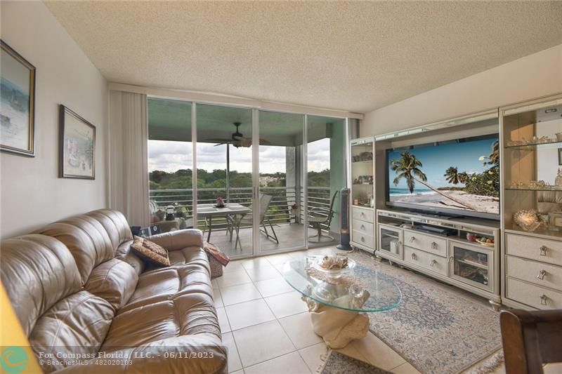 9470 Poinciana Place, Unit 405 Davie, FL 33324 - Photo 1 of 23 a living room with furniture and a floor to ceiling window