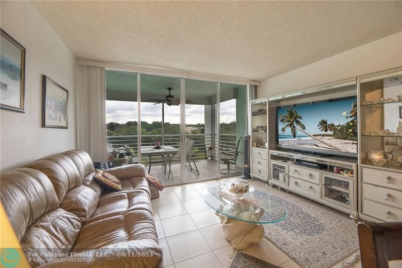 a living room with furniture and a floor to ceiling window