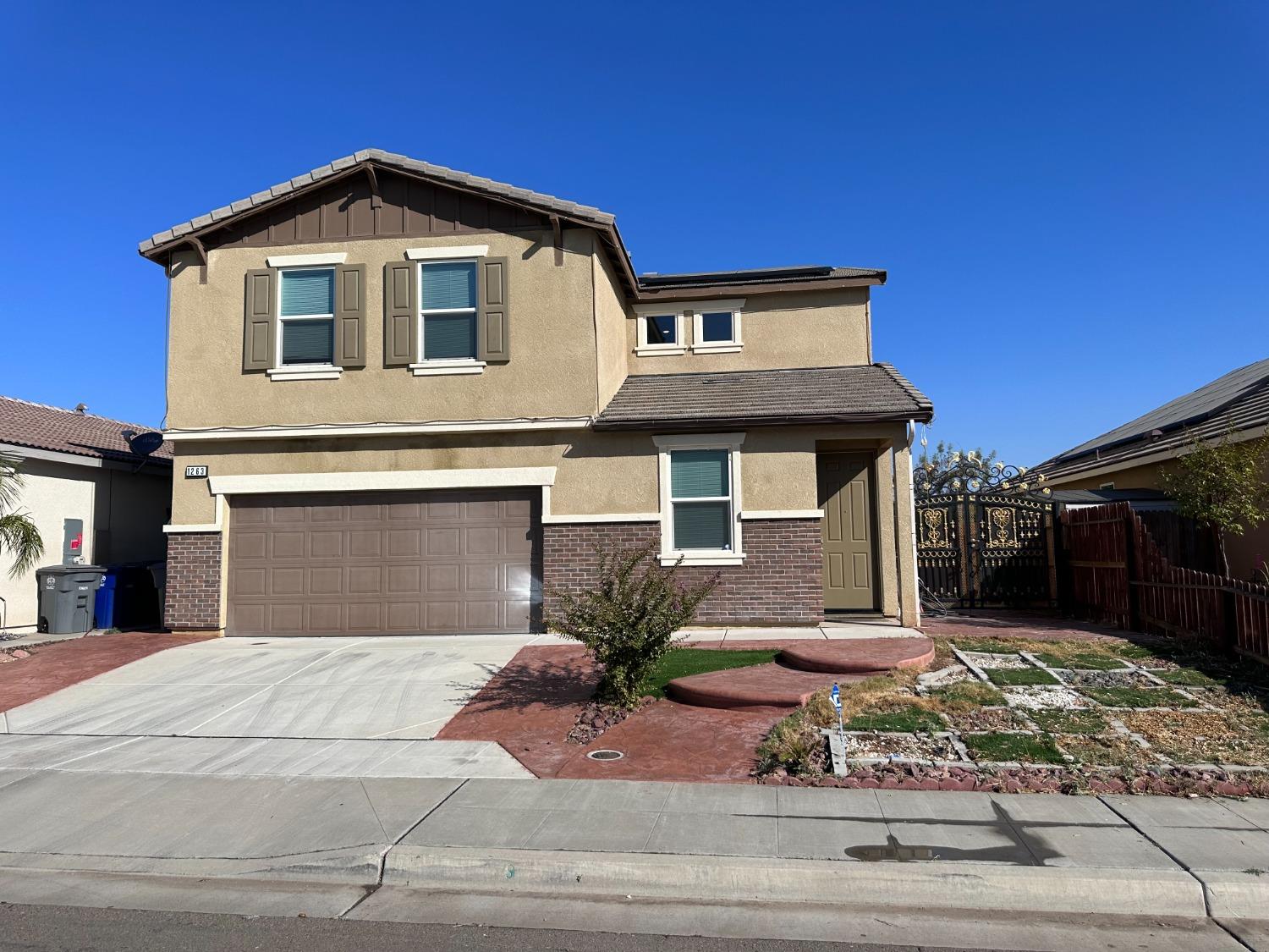 1263 Padre Street Madera, CA 93638 - Photo 1 of 26 a front view of a house with a yard and garage
