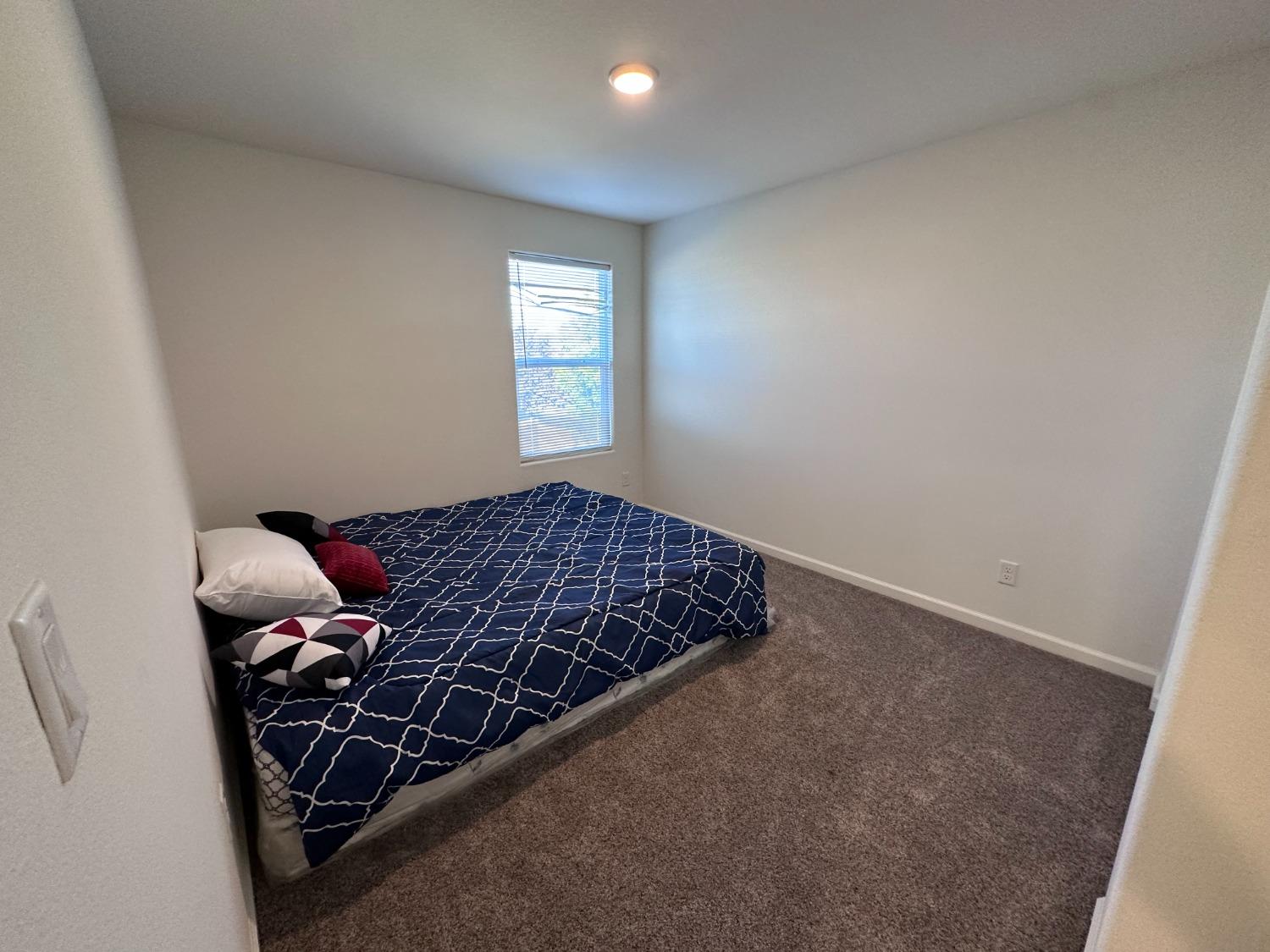 1263 Padre Street Madera, CA 93638 - Photo 21 of 26 a bed sitting in a bedroom next to a window
