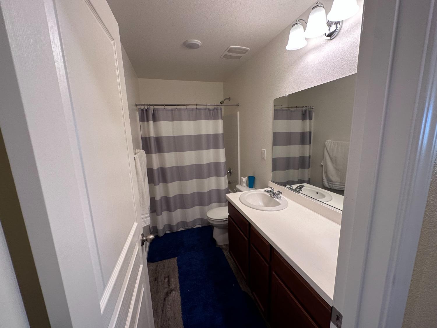1263 Padre Street Madera, CA 93638 - Photo 24 of 26 a bathroom with a sink a toilet a shower and a mirror