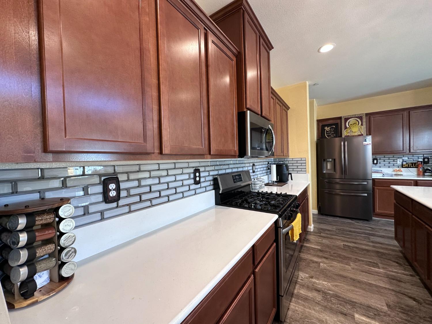 1263 Padre Street Madera, CA 93638 - Photo 7 of 26 a kitchen with stainless steel appliances a sink stove and refrigerator