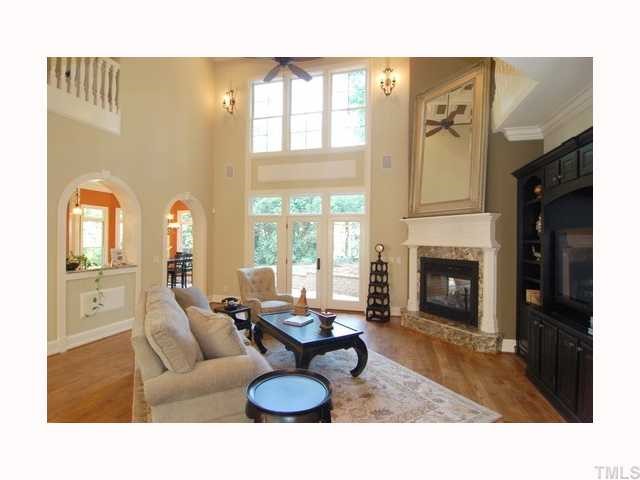 3400 Lake Boone Trail Raleigh, NC 27607 - Photo 4 of 12 a living room with furniture a fireplace and a floor to ceiling window