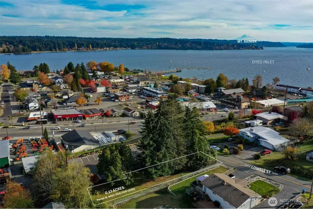 an aerial view of a city with lots of residential buildings ocean and mountain view in back