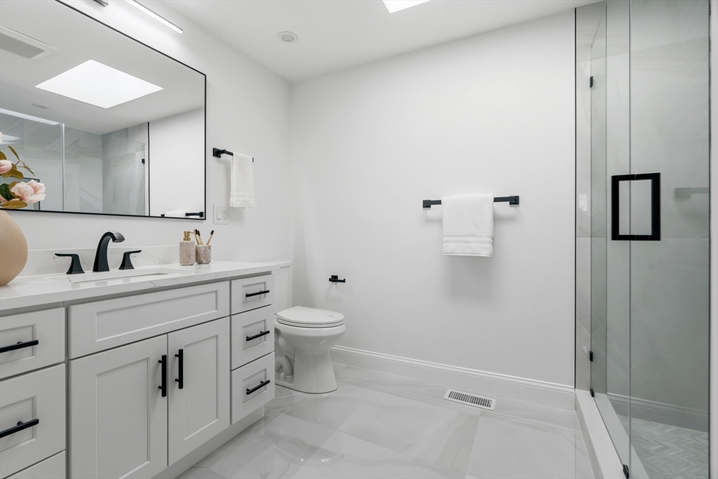 171 Shaw Road Brookline, MA 02467 - Photo 22 of 42 a bathroom with a toilet sink and mirror