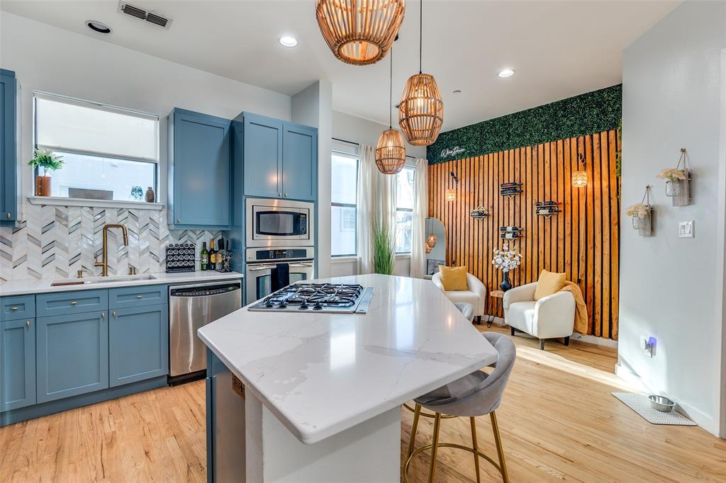 1016 Liberty Street, Unit 2 Dallas, TX 75204 - Photo 4 of 24 a kitchen with stainless steel appliances wooden floor dining table and chairs