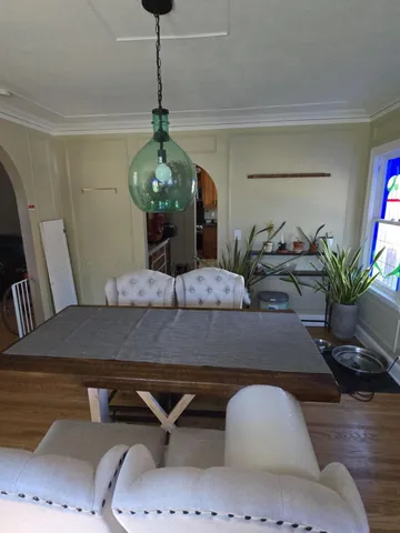 a dining room with table chairs and potted plants