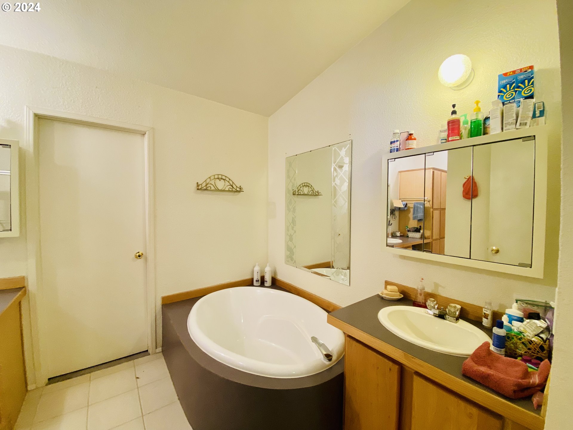 657 54th Street Springfield, OR 97478 - Photo 16 of 28 a bathroom with a sink and mirror with bathtub