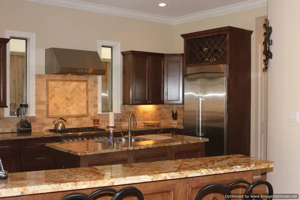 a kitchen with granite countertop a refrigerator and a sink