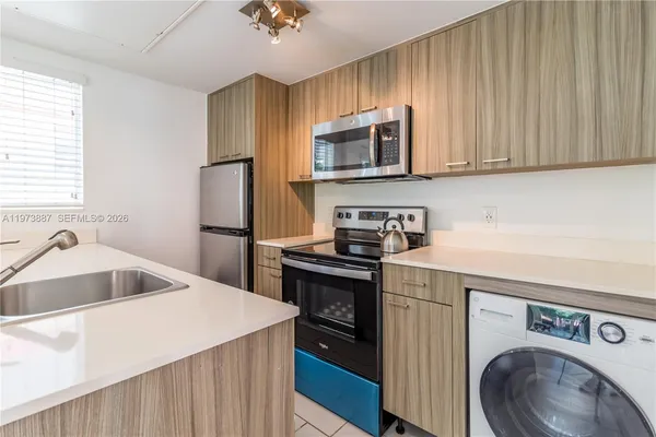 a kitchen with stainless steel appliances granite countertop a sink a stove and a refrigerator