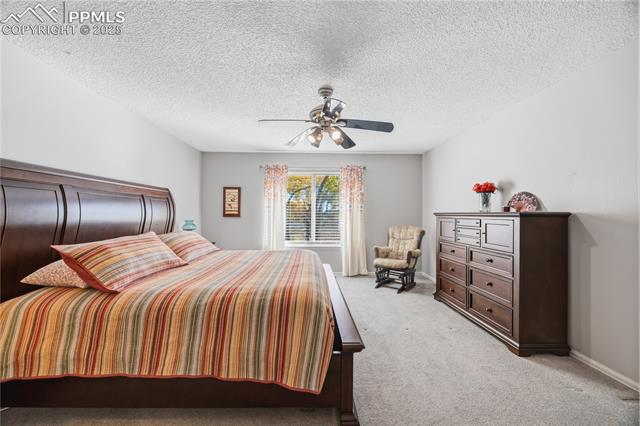 2135 Glenhill Road Colorado Springs, CO 80906 - Photo 22 of 50 Bedroom featuring carpet floors, a textured ceiling, and ceiling fan