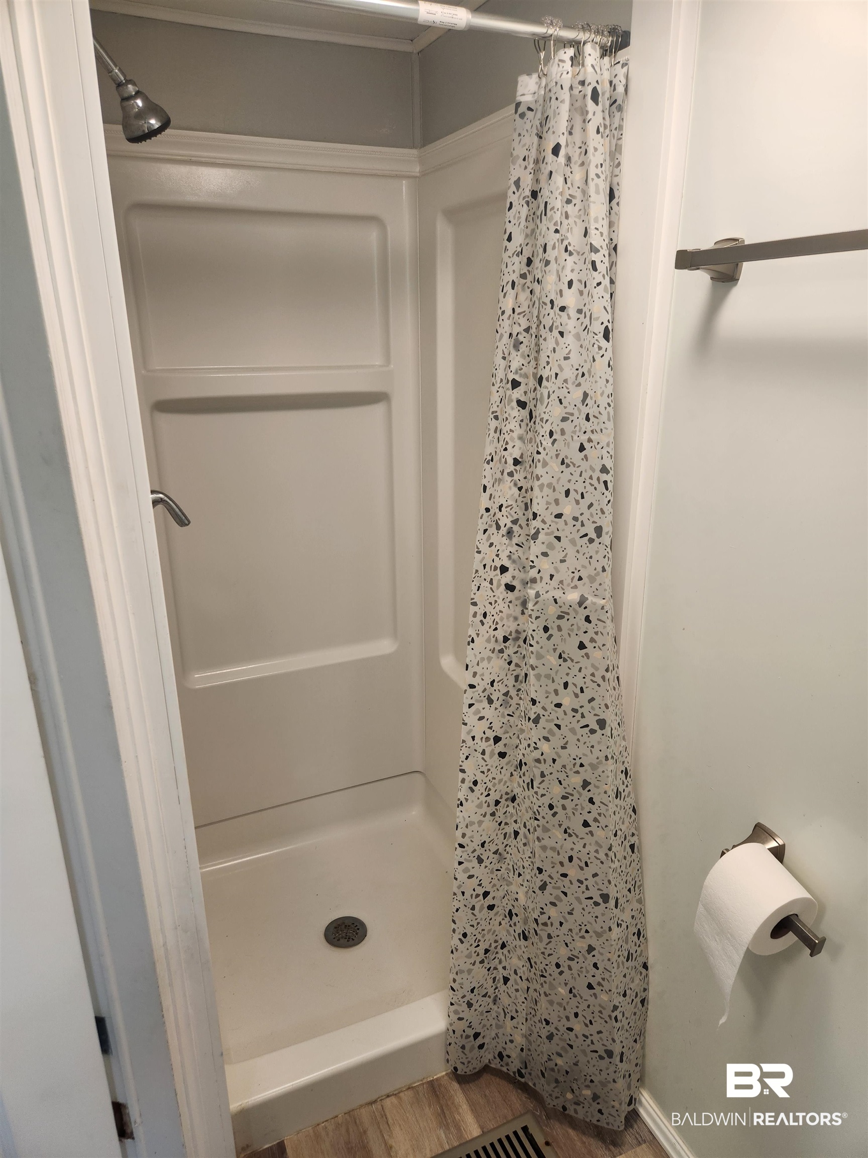 23051 Fritz Lane Foley, AL 36535 - Photo 15 of 26 White shower stall with a brushed chrome shower head and a patterned shower curtain