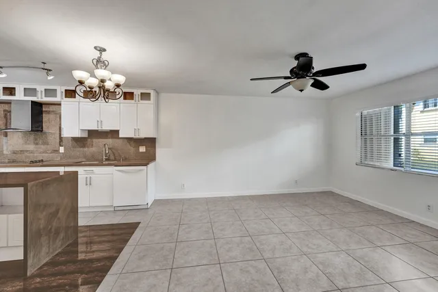 a kitchen with granite countertop a white cabinets and window