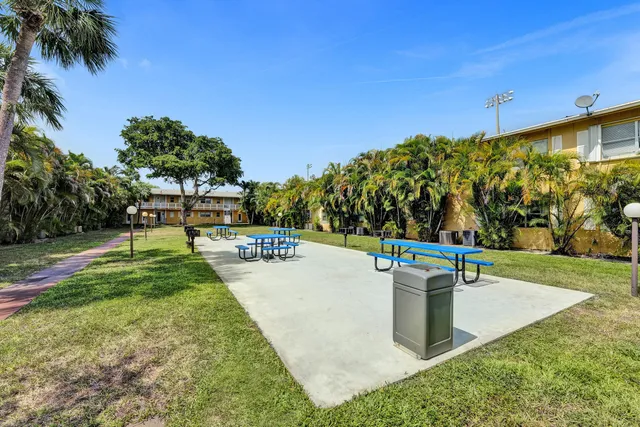 a view of a swimming pool with a bench and trees