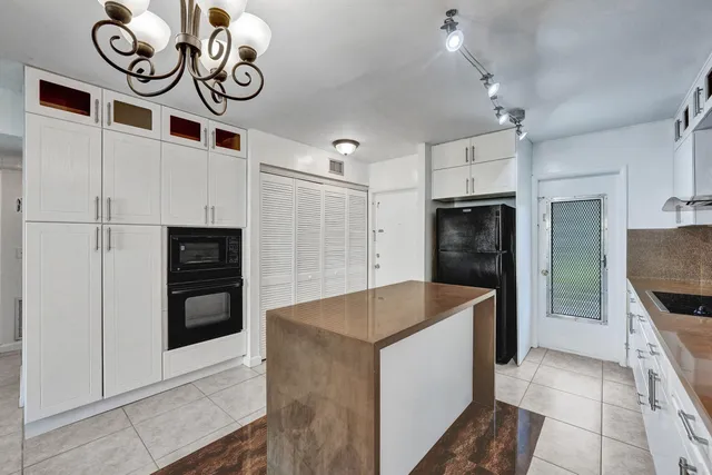 a kitchen with stainless steel appliances granite countertop a sink and a refrigerator