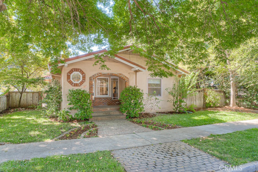 944 Ivy Street Chico, CA 95928 - Photo 1 of 1 a view of a white house with a big yard and large tree and plants