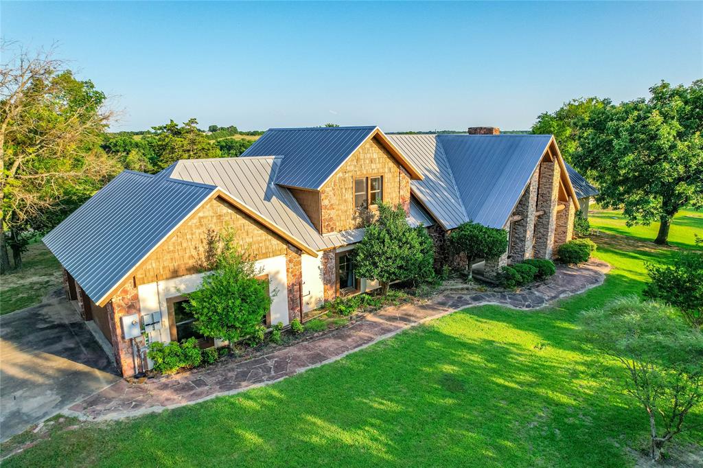 1922 A Bethel-Cannon Road Whitewright, TX 75491 - Photo 3 of 40 Stone and shingle exterior featuring a metal roof, extensive lawn, and mature landscaping