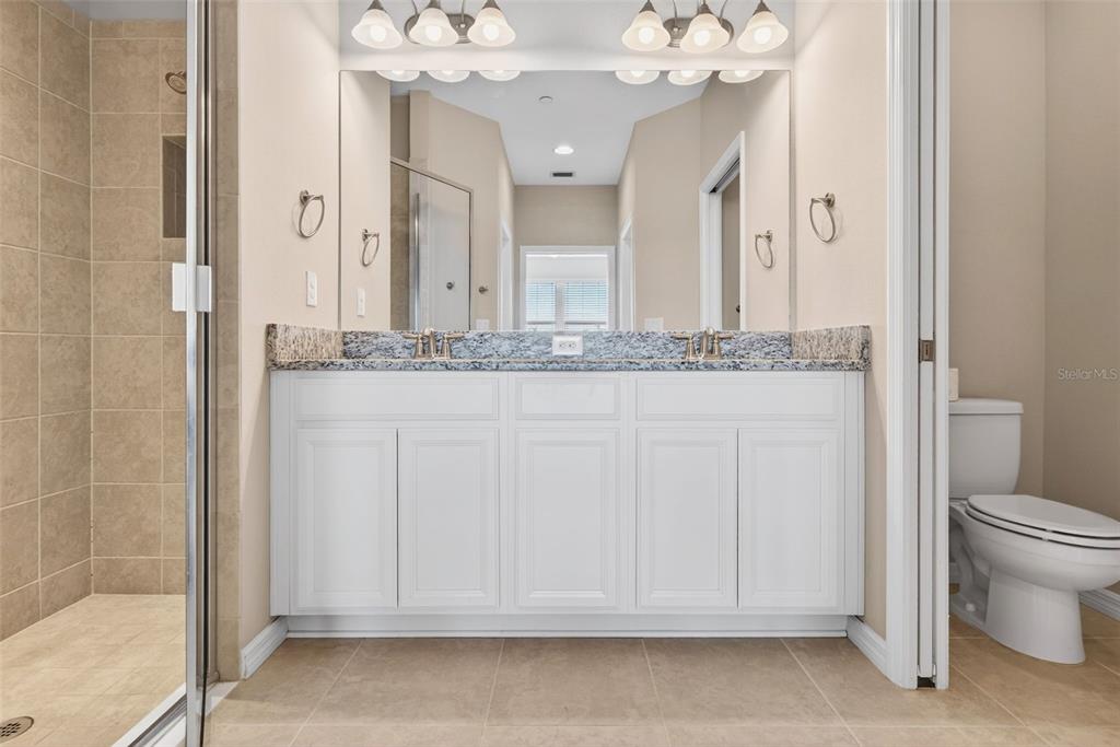 13738 Messina Loop, Unit 103 Bradenton, FL 34211 - Photo 41 of 99 a bathroom with a granite countertop sink a toilet and a mirror