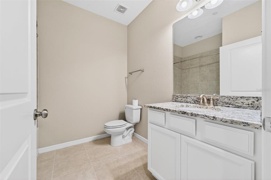 13738 Messina Loop, Unit 103 Bradenton, FL 34211 - Photo 48 of 99 a bathroom with a granite countertop toilet a sink and a mirror