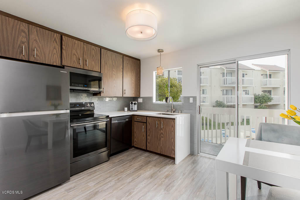 209 South Ventura Road, Unit 31 Port Hueneme, CA 93041 - Photo 7 of 41 a kitchen with granite countertop wooden floors and stainless steel appliances