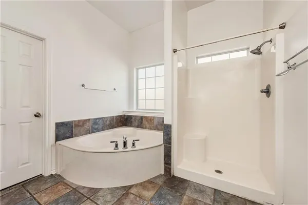 a white bath tub sitting next to a shower
