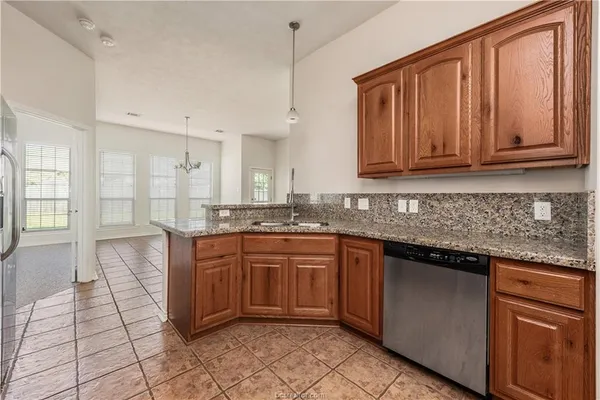 a kitchen with stainless steel appliances granite countertop a refrigerator and wooden cabinets