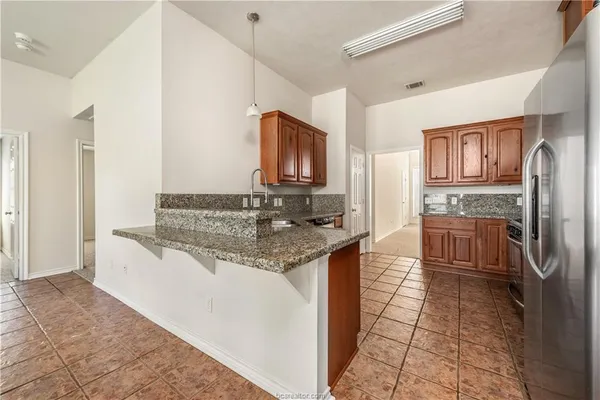 a kitchen with stainless steel appliances granite countertop a sink stove and refrigerator