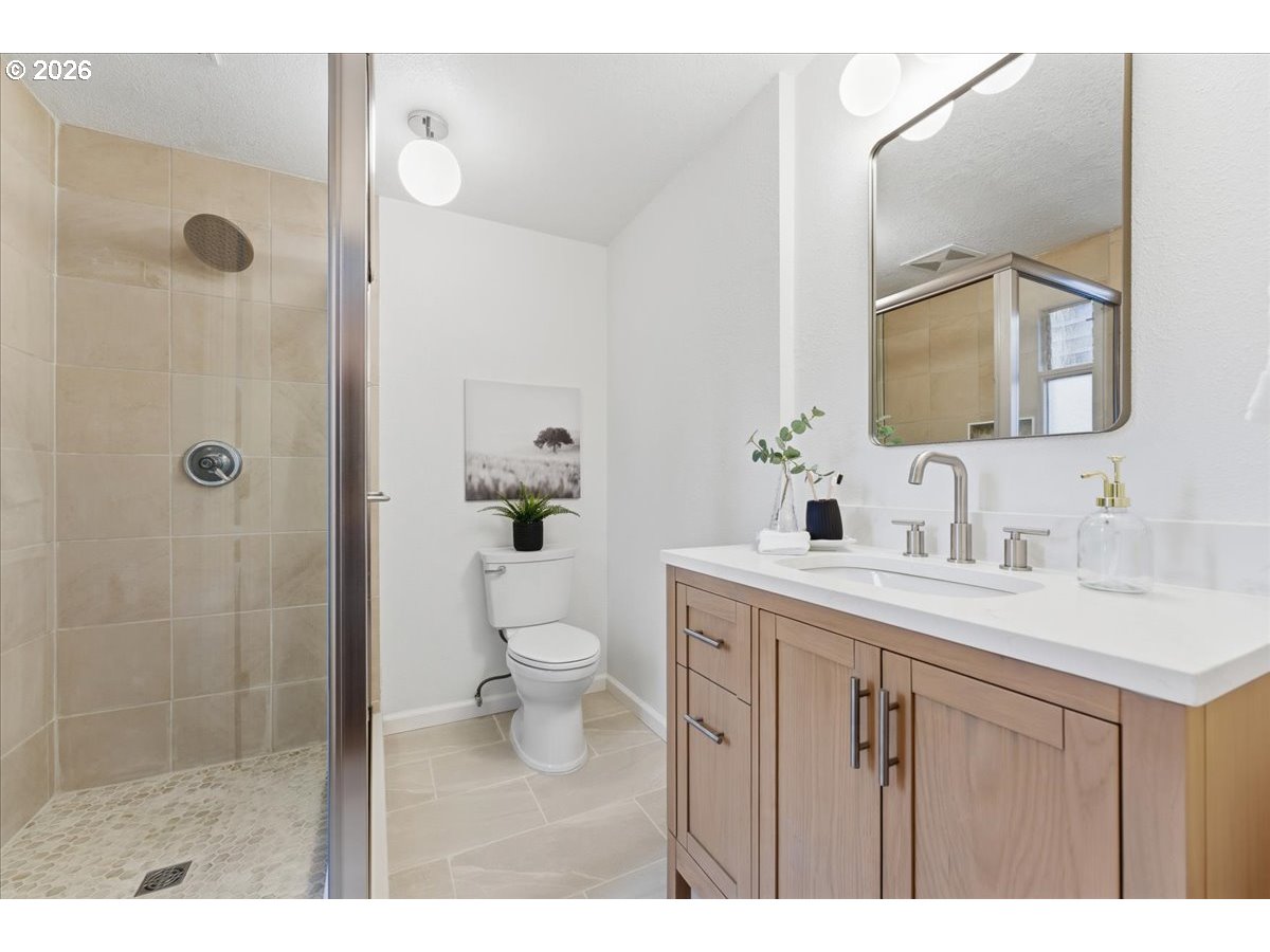 14825 Southwest Village Lane Beaverton, OR 97007 - Photo 19 of 32 a bathroom with a sink toilet a mirror and shower