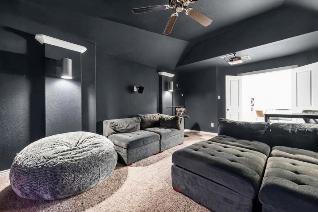 10114 Brush Way Rosharon, TX 77583 - Photo 33 of 50 Experience ultimate relaxation in this cozy media room featuring plush seating, soft lighting, and dark walls for a perfect cinematic ambiance.