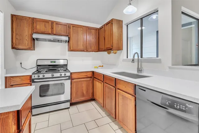 a kitchen with stainless steel appliances a stove sink and cabinets