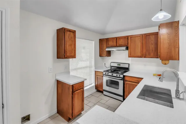 a kitchen with stainless steel appliances granite countertop a stove a sink and a refrigerator