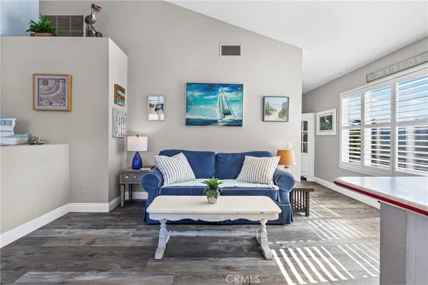 a living room with furniture a flat screen tv and kitchen view