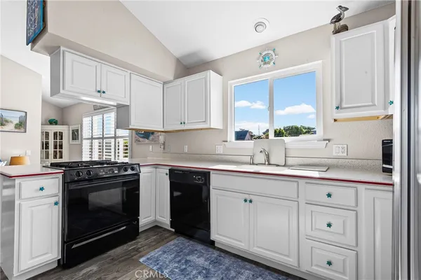 a kitchen with stainless steel appliances granite countertop a refrigerator sink and white cabinets