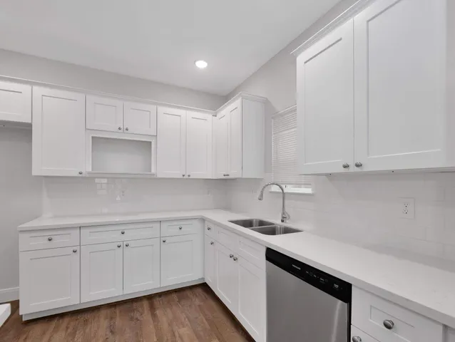 a kitchen with white cabinets and white appliances
