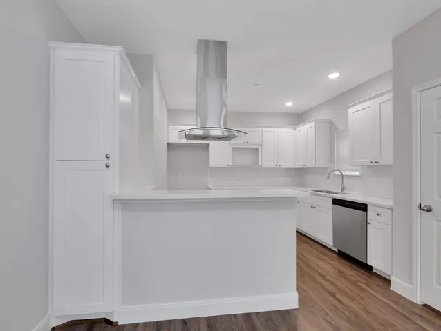 a kitchen with kitchen island a sink stainless steel appliances and cabinets