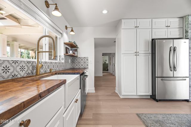 a large kitchen with granite countertop a refrigerator and a sink