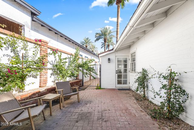 a porch with a table and chairs and potted plants