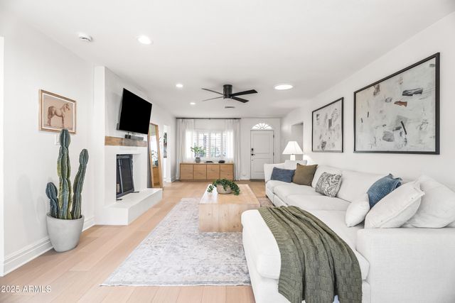 a living room with furniture a flat screen tv and a fireplace