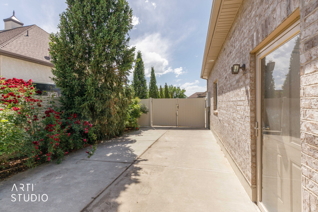 2327 Bluff Ridge Drive Syracuse, UT 84075 - Photo 55 of 66 Side yard featuring a concrete pathway, mature evergreen trees, and a privacy fence