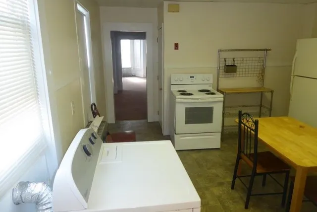 a kitchen with a sink a refrigerator and cabinets