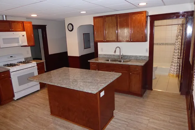 a kitchen with a refrigerator sink and cabinets