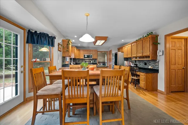 a dining room with furniture a chandelier and wooden floor